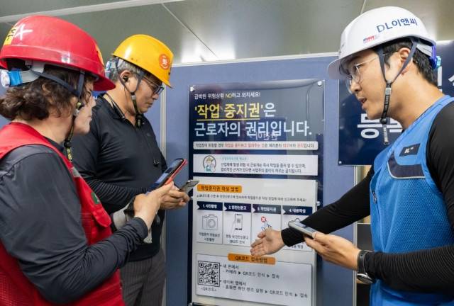 DL이앤씨 현장 안전관리자(오른쪽)가 현장 노동자들에게 안전신문고 접속 및 작업중지권 사용법에 대해 설명하고 있다. DL이앤씨 제공