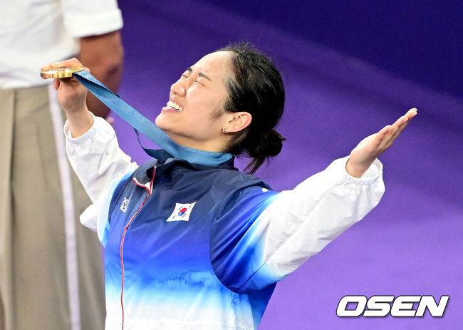[OSEN=파리(프랑스), 최규한 기자] 5일(한국시간) '셔틀콕 여제' 안세영(22, 삼성생명)이 꿈에 그리던 올림픽 금메달을 목에 걸었다.세계 랭킹 1위 안세영은&nbsp;5일 오후(이하 한국시간) 프랑스 파리 포르트 드 라샤펠 경기장에서 열린 2024 파리올림픽 배드민턴 여자 단식 결승전에서 랭킹 9위 허빙자오(중국)를 2-0으로 꺾고 금메달을 획득 했다. &nbsp;한국 안세영이 시상식에서 금메달을 들고 기뻐하고 있다. 2024.08.05 / dreamer@osen.co.kr