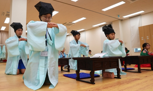 “전통 예절교육 배워요” - 5일 오전 부산 동래구 충렬사 안락서원 교육회관에서 열린 초등학교 여름방학 전통문화 체험교실에 참가한 학생들이 한복을 차려입고 예절교육을 받고 있다. 부산 연합뉴스