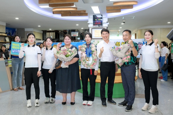 순천시청 1층 로비에서 열린 귀국 환영식에서 남수현과 어머니 고수진, 노관규 시장, 임동일 순천시청양궁부 감독과 선수들이 기념사진을 찍고 있다.