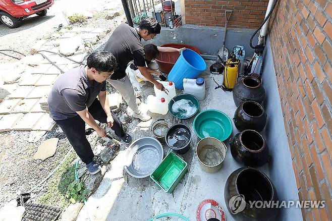 폭염에 단수…물 받기 위한 양동이들 (청도=연합뉴스) 윤관식 기자 = 5일 경북 청도군 풍각면 한 가정집이 단수된 가운데 풍각면사무소 직원이 급수 지원을 하고 있다.
    청도군은 전체 물 사용량이 생산량을 넘어서면서 전날 오후부터 일부 지역에서 물을 사용하지 못하고 있다. 2024.8.5 psik@yna.co.kr