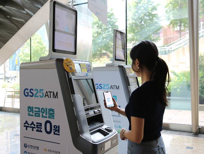 GS25 매장 내 스마트 ATM에서 2분만에 해외여행 카드를 발급받을 수 있다. 사진은 모델이 GS25 ATM에서 여행카드를 발급받는 모습. /사진=GS리테일