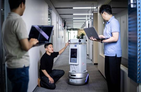 SK텔레콤 연구원들이 경기 성남시 분당구 판교 사옥에서 자사의 텔코 에지 인공지능(AI) 인프라를 기반으로 한 자율주행 로봇 기술 실증을 진행하고 있다. SK텔레콤 제공