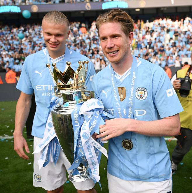 지난 5월 프리미어리그 우승 트로피를 들고 있는 케빈 더 브라위너(오른쪽)와 엘링 홀란. Getty Images코리아