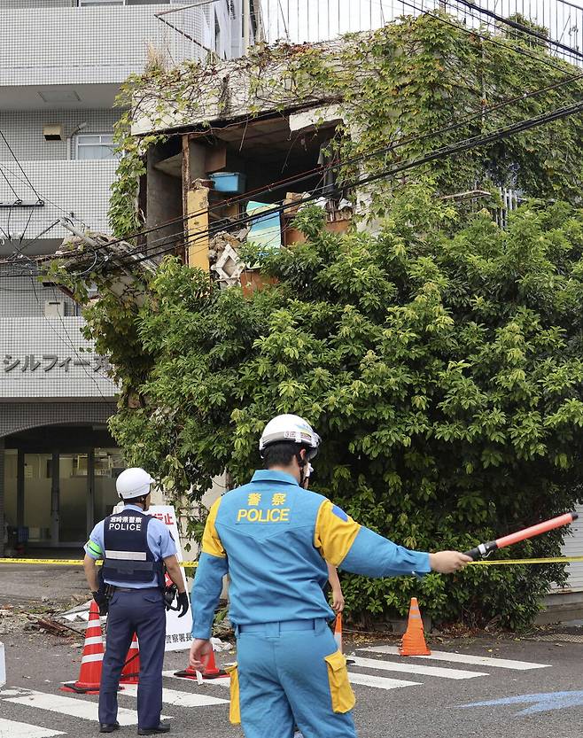 8일 규모 7.1 지진이 일어난 일본 미야자키현에서 경찰이 지진으로 손상을 입은 건물 주변에서 경계를 하고 있다. 로이터 연합뉴스