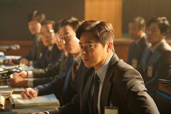 조정석은 영화 <행복의 나라>에서 10·26 사건에 가담한 박흥주 대령을 도왔던 변호인단을 종합한 캐릭터 ‘정인후’를 연기한다. NEW 제공