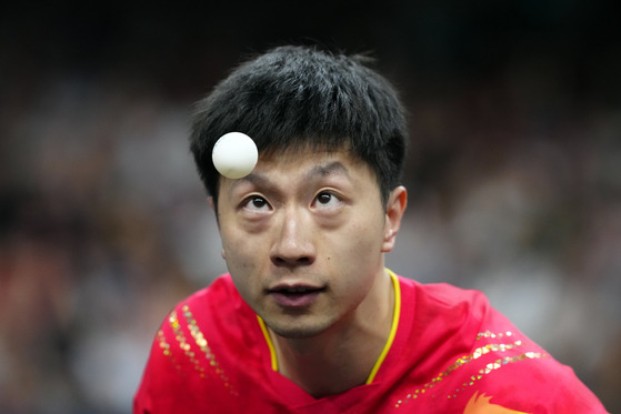 China's Ma Long, with his teammate Wang Chuqin, plays against South Korea's Cho Dae-seong and Jang Woo-jin during a men's team quarterfinal table tennis match on Wednesday in Paris. [AP/YONHAP]