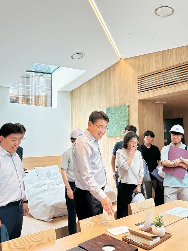 오승록(가운데) 노원구청장이 최근 만들어진 ‘동막골 휴양림’의 샘플하우스 내부에서 비치된 물품을 점검하며 관계자들과 이야기를 나누고 있다.  노원구청 제공
