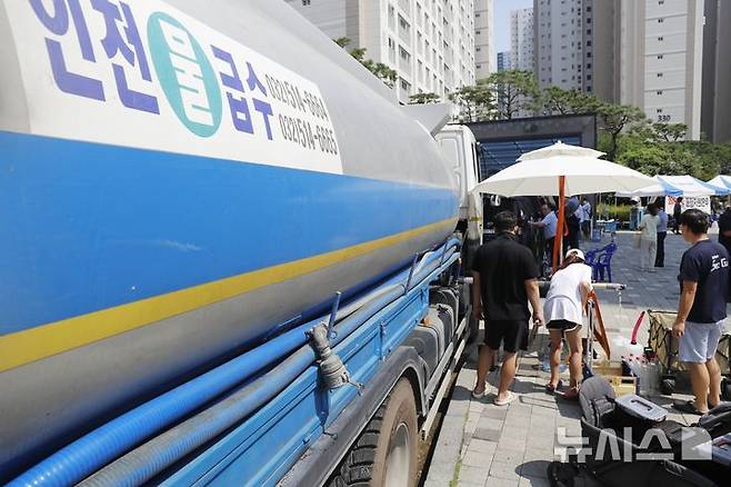 [인천=뉴시스] 김동영 기자 = 폭염주의보가 내려진 5일 오후 인천 서구 청라동 전기차 화재가 발생한 아파트 주민들이 급수차에서 물을 지원 받고 있다. 이 화재로 해당 아파트에서는 단전·단수가 5일째 이어지고 있다. 2024.08.05. dy0121@newsis.com