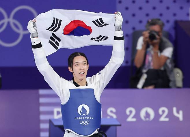 8일(현지시간) 프랑스 파리 그랑팔레 태권도경기장에서 열린 2024 파리올림픽 태권도 여자 57kg급 결승에서 한국의 김유진이 이란의 나히드 키야니찬데를 꺾고 금메달을 확정한 뒤 태극기를 들고 환호하고 있다. 사진=연합뉴스