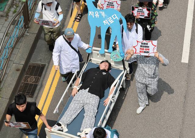 9일 오전 한국정신장애인연합회 등 29개 정신장애인 단체 회원들이 환자를 침대에 강박하는 행위극을 하며 부천시 원미구 부천더블유(W)진 병원 앞에서 부천시 보건소까지 행진하고 있다. 김영원 기자 forever@hani.co.kr