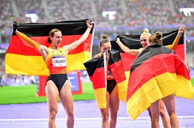 파리 올림픽 육상 여자 400m 계주 결승전에서 3위에 올라 동메달을 따낸 독일 대표팀 선수들이 국기를 펼쳐 보이며 기뻐하고 있다. AFP연합뉴스
