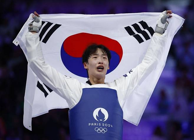 이다빈이 11일 오전(한국시간) 프랑스 파리의 그랑팔레에서 열린 2024 파리 올림픽 태권도 여자 67㎏ 이상급 동메달 결정전에서 로레나 브란들(독일)을 상대로 2-1 승리를 거둔 뒤 태극기를 들어올리고 있다. [이미지출처=로이터연합뉴스]