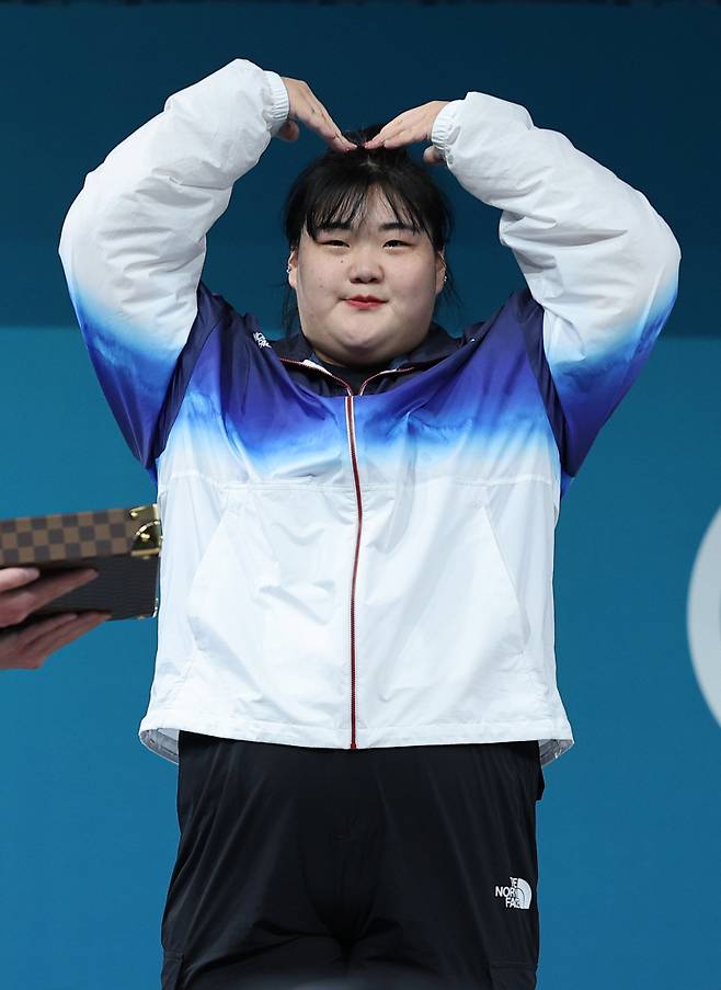 <yonhap photo-8923=""> 박혜정 '사랑합니다' (파리=연합뉴스) 임화영 기자 = 11일(현지시간) 프랑스 파리 사우스 파리 아레나에서 열린 2024 파리올림픽 역도 여자 81kg 이상급에서 은메달을 따낸 박혜정이 시상대에 올라 팔로 하트모양을 그려보이고 있다. 2024.8.11 hwayoung7@yna.co.kr/2024-08-11 21:45:02/ <저작권자 ⓒ 1980-2024 ㈜연합뉴스. 무단 전재 재배포 금지, AI 학습 및 활용 금지></yonhap>