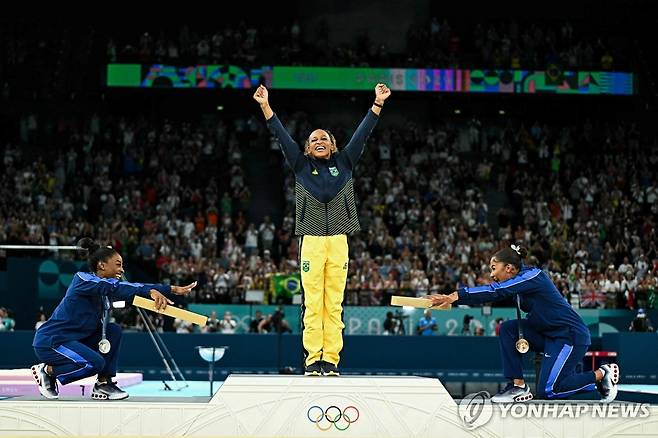 시상대에서 시몬 바일스(왼쪽)와 조던 차일스에게 축하받는 레베카 안드라드 [AFP=연합뉴스] [2024.08.06 송고]