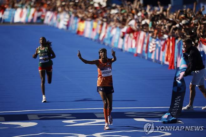 가장 먼저 결승선 통과하는 하산 (파리 EPA=연합뉴스) 하산이 11일(한국시간) 프랑스 파리에서 열린 2024 파리 올림픽 여자 마라톤에서 가장 먼저 결승선을 통과하고 있다.