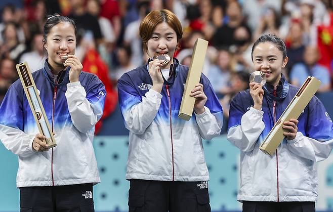 신유빈, 이은혜, 전지희(왼쪽부터)가 10일(현지시간) 프랑스 파리 사우스 파리 아레나에서 열린 2024 파리올림픽 여자 단체전 시상식에서 동메달을 전달받은 뒤 메달에 입맞춤하고 있다. 연합뉴스