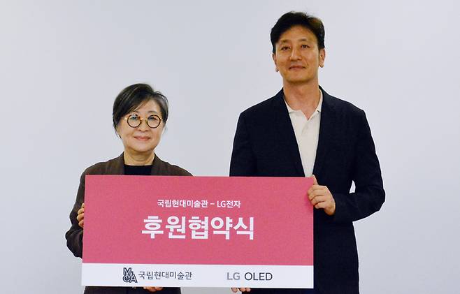 김성희 국립현대미술관 관장(왼쪽)과 오승진 LG전자 한국 HE/BS 마케팅담당 상무가 LG전자·국립현대미술관 3년 전시 후원 협약을 체결하고 기념 촬영을 하고 있다. <LG전자>