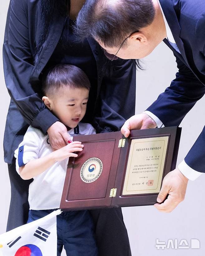 [서울=뉴시스] 황준선 기자 = 12일 오후 서울 서대문구 대한민국임시정부 기념관에서 열린 제79주년 광복절 기념 독립유공자 후손 대한민국 국적증서 수여식에서 최찬식 독립유공자의 후손 최다닐 군이 박성재 법무부 장관에게 국적증서를 수여받고 있다. 2024.08.12. hwang@newsis.com