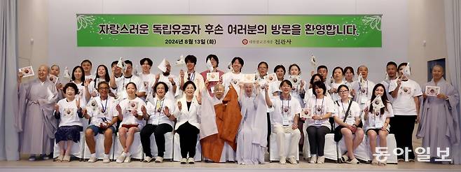 13일 서울 은평구 진관사 한문화체험관에서 스님들과 독립유공자 후손들이 진관사 태극기를 흔들며 기념 촬영을 하고 있다. 전영한 기자 scoopjyh@donga.com