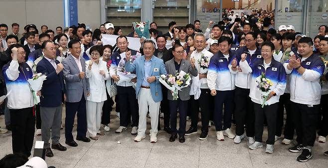 Team Korea’s delegation to the Paris Olympics, including Lee Kee-heung, president of the Korean Sport & Olympic Committee (KSOC), is surrounded by media at Incheon International Airport Tuesday. [NEWS1]