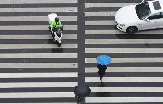 배달오토바이가 보행자 신호로 바뀐 횡단보도를 침범해 시민의 안전을 위협하고 있다.