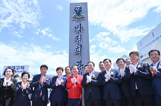 홍준표 대구시장(가운데)과 내빈들이 14일 오전 대구 동구 동대구역 앞 광장에서 열린 ‘박정희광장 표지판 제막식’에 참석해 박수를 치고 있다. 대구시 제공