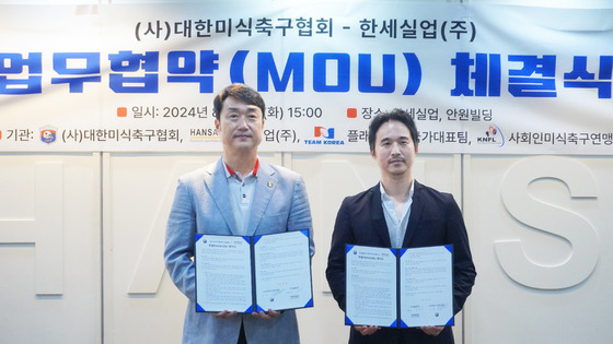 Kim Ik-hwan, vice chairman of Hansae, right, and Ryu Ho-jung, chairman of Korea American Football Association, pose for a photo after signing a partnership at Hansae's Yeouido headquarters in western Seoul on Tuesday. [HANSAE]