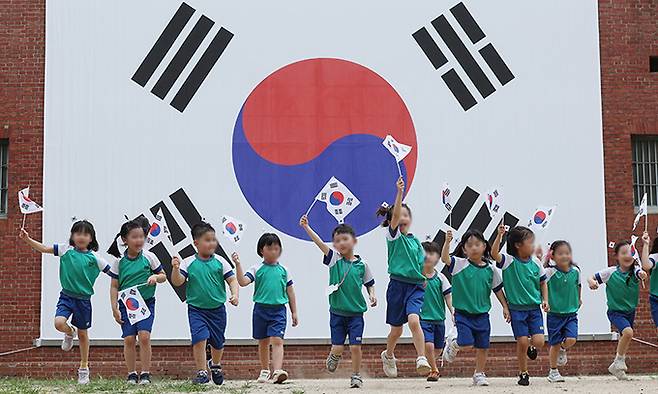 광복절을 하루 앞둔 14일 서울 서대문형무소역사관에서 어린이들이 태극기를 배경으로 기념촬영을 하고 있다. 연합뉴스