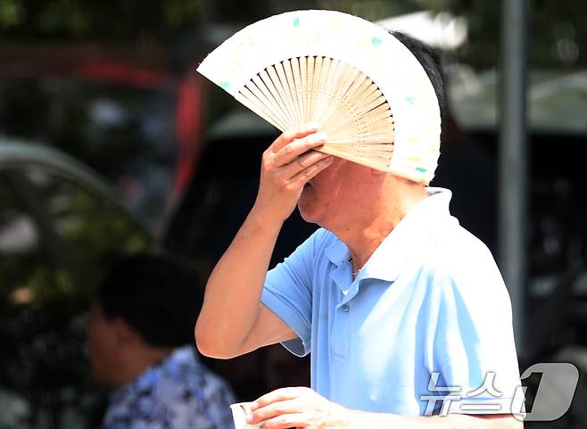 부산에 10일째 폭염경보가 이어진 5일 오후 부산 연제구 녹음공원에서 한 시민이 부채로 햇빛을 가리며 이동하고 있다. 2024.8.5/뉴스1 ⓒ News1 윤일지 기자