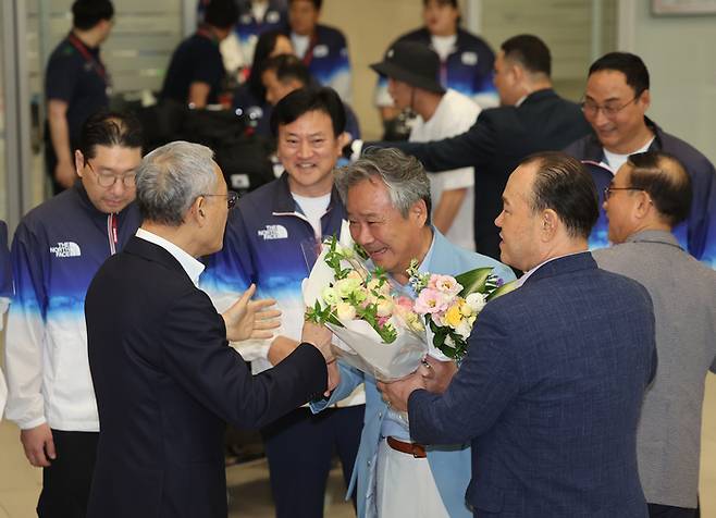 이기흥 대한체육회장(가운데)이 13일 인천국제공항 제2여객터미널을 통해 귀국해 유인촌 문화체육관광부 장관과 인사를 나누고 있다. 사진 | 인천국제공항=연합뉴스