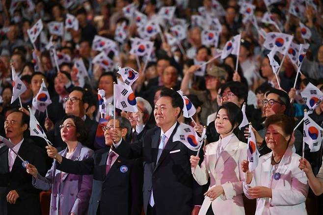 윤석열 대통령과 부인 김건희 여사가 15일 서울 종로구 세종문화회관에서 열린 제79주년 광복절 경축식에서 광복절의 노래에 맞춰 태극기를 흔들고 있다. ⓒ대통령실