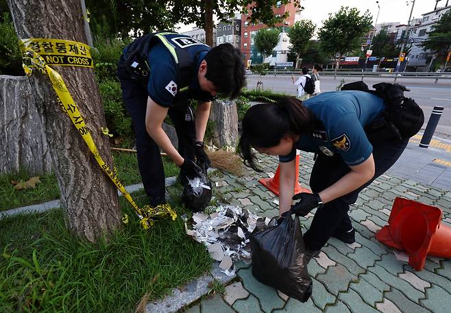 Police inspect the content of what is thought to be a trash-carrying balloon floated over the border by North Korea, which landed at Yonsei University in Seodaemun-gu, Seoul, July 24. (Yonhap)