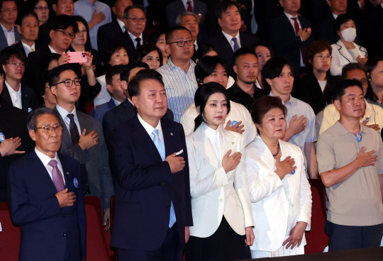 윤석열 대통령과 김건희 여사가 15일 서울 종로구 세종문화회관에서 열린 제79주년 광복절 경축식에서 이동일 순국선열유족회장 등 참석자들과 함께 국기에 대한 경례를 하고 있다. 연합뉴스