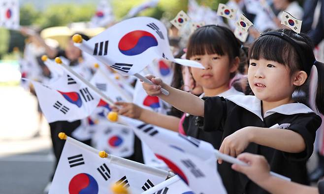 13일 대구 북구 동화훼밀리타운 아파트에서 열린 ‘광복 79주년 나라사랑 전 세대 태극기 달기 운동’에서 어린이집 원생들이 태극기를 흔들고 있다. 대구=뉴시스