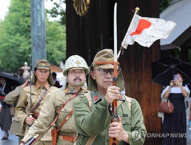 군복 입고 야스쿠니신사 앞 행진하는 사람들 (도쿄=연합뉴스) 박상현 특파원 = 일본 패전일인 15일 태평양전쟁 A급 전범이 합사된 도쿄 지요다구 야스쿠니신사에서 군복을 입은 사람들이 칼을 들고 행진하고 있다. 2024.8.15
