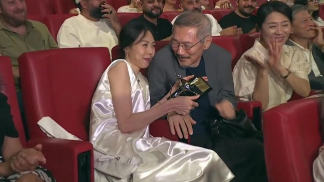 “By the Stream” actor Kim Min-hee (left) and director Hong Sang-soo (right) celebrate Kim’s award during the 77th Locarno International Film Festival in Locarno, Switzerland, on Saturday. (Screen capture from Locarno International Film Festival Youtube)