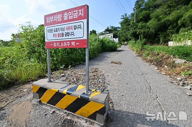 [광주-뉴시스] 이영주 기자 = 16일 오전 광주 서구 마륵동 한 농촌 길에 통행을 금지하는 사유지 표지판이 세워져있다. 길이 30m·너비 2m 남짓 농로 위에 설치된 해당 표지판은 마을 주민과 토지주 사이 갈등 끝에 세워진 것으로 전해졌다. 2024.08.16. leeyj2578@newsis.com