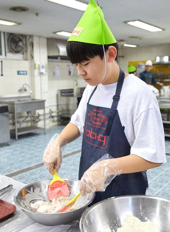 볼에 넣은 닭 조각 위로 물에 타서 만든 반죽을 넣어준 후 고무주걱으로 잘 버무려주고 있는 황원교 학생기자.