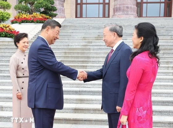 19일 오전 베이징 인민대회당 동문 광장에서 시진핑(왼쪽 두번째) 중국 국가주석이 또 럼(오른쪽 두번째) 베트남 국가주석을 만나 악수하고 있다. 사진 베트남통신사 홈페이지 캡처