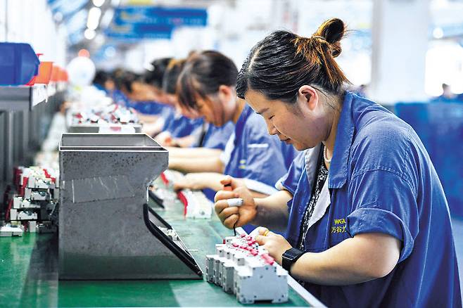 중국 동부 안후이성 푸양에 있는 한 전자회사 공장의 차단기 생산라인에서 근로자들이 지난달 30일 작업을 하고 있다. [AFP]