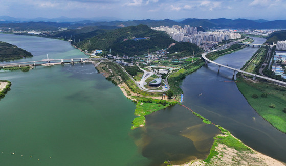 A section of Nakdong River, left, is filled with toxic algae bloom as a joint civil defense drill, simulating a response to water pollution from drone attacks, takes place near Geumho River in Daegu, North Gyeongsang, on Tuesday. [YONHAP]