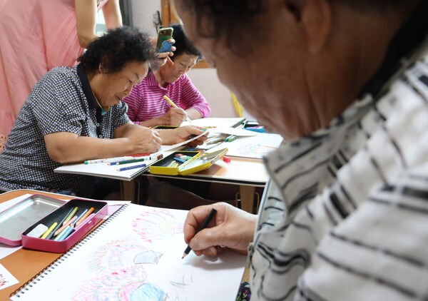 산청 할매 시인 학교 수업에서 원산마을 할매들이 그림 그리기에 몰두하고 있다./백솔빈 기자