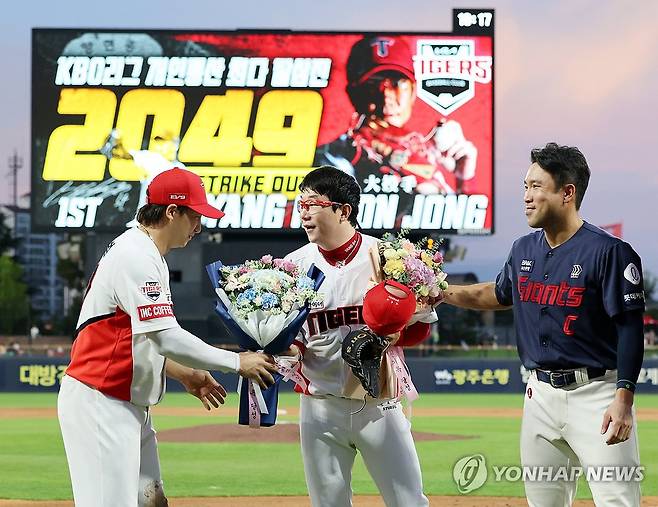 축하받는 양현종, KBO 역대 최다 탈삼진 기록 달성 (광주=연합뉴스) 조남수 기자 = 21일 광주기아챔피언스필드에서 열린 프로야구 롯데 자이언츠와 KIA 타이거즈의 경기. KBO 역대 최다 탈삼진 기록을 달성한 KIA 양현종이 양 팀 주장인 전준우와 나성범으로부터 축하의 꽃다발을 받고 있다. 2024.8.21 iso64@yna.co.kr