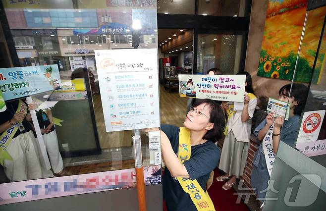 22일 광주 북구청 보건위생과 식품가공팀 직원들이 한 음식점에서 여름철 식중독 예방과 음식 재사용 안하기 등 음식문화 개선을 위해 홍보물을 나눠주며 캠페인을 펼치고 있다.(광주 북구 제공)2024.7.22/뉴스1