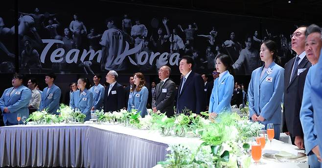 윤석열 대통령과 김건희 여사가 22일 서울 한 호텔에서 열린 ‘2024 파리올림픽 선수단 격려 행사’에서 정의선 현대차그룹 회장, 유인촌 문화체육관광부 장관, 올림픽 참가 선수들과 애국가를 부르고 있다. 사진 | 연합뉴스