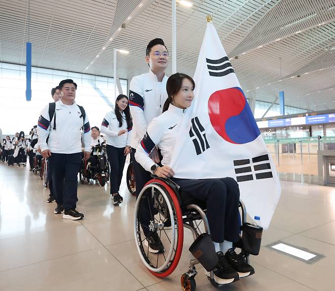 <yonhap photo-2617=""> 21일 인천국제공항을 통해 프랑스 파리로 출국한 패럴림픽 대표팀. 조은혜가 태극기를 들고 앞장 서 나섰다. 연합뉴스</yonhap>