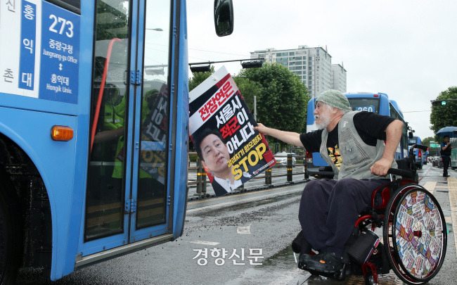 박경석 전국장애인차별철폐연대 대표가 지난해 7월18일 서울 종로4가 버스정류장에서 오세훈 서울시장의 전장연 탄압 중단을 촉구하는 ‘비폭력·불복종 버스행동’ 시위를 벌이고 있다. 서성일 선임기자