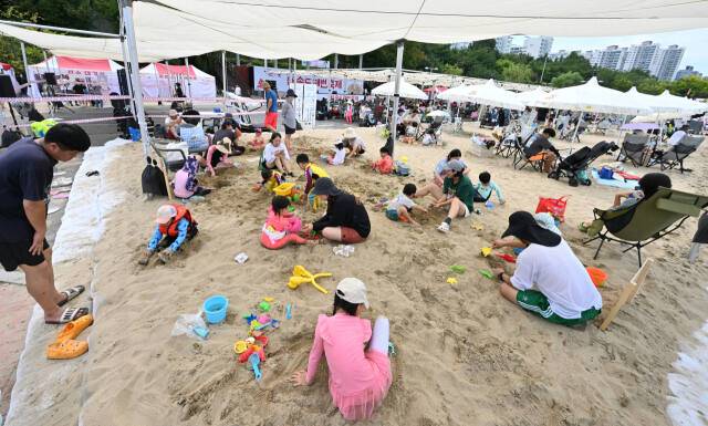 지난 10일 인천 연수구 송도 달빛공원에서 열린 ‘제5회 新송도해변축제’ 인공해변에서 아이들과 모래놀이를 하고 있다. 조병석기자