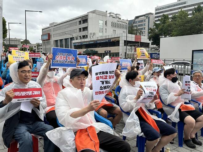 배달 플랫폼의 수수료 인상을 규탄하는 집회에서 참가자가 '플랫폼을 위한 음식값 상승은 가게도 소비자도 원하지 않는다'라는 팻말을 들고 있다. ⓒ시사저널 정윤경